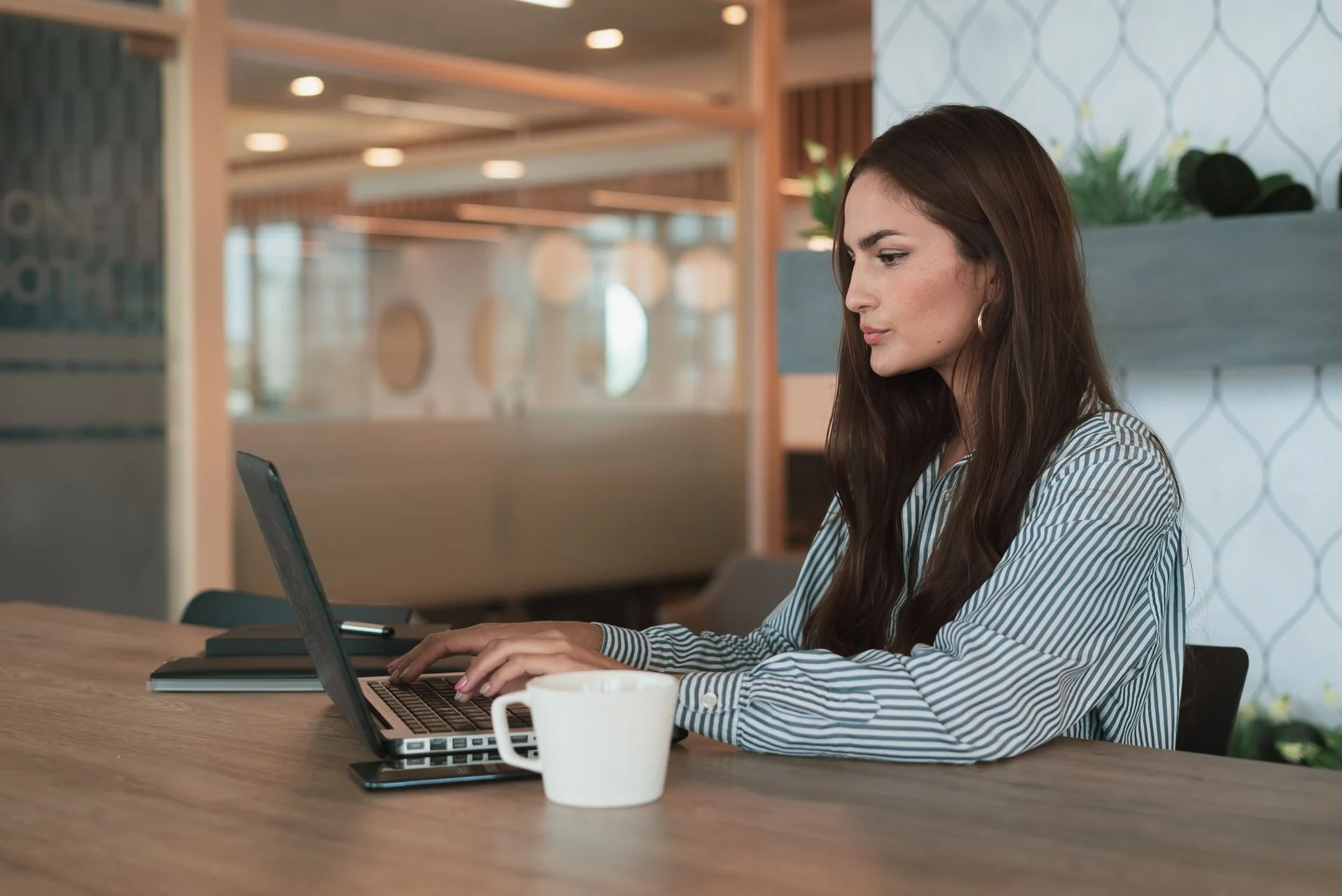 A consultant working at a laptop, with her week's meetings already in her calendar
